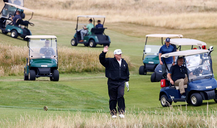 U.S. President Donald Trump gestures as he walks on the course of his golf resort, in Turnberry