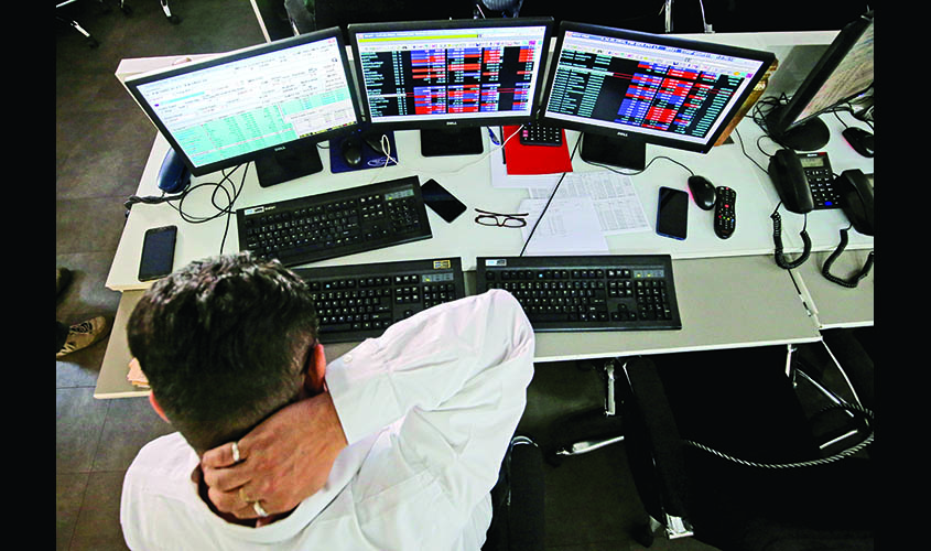 A broker reacts while trading at his computer terminal at a stock brokerage firm in Mumbai