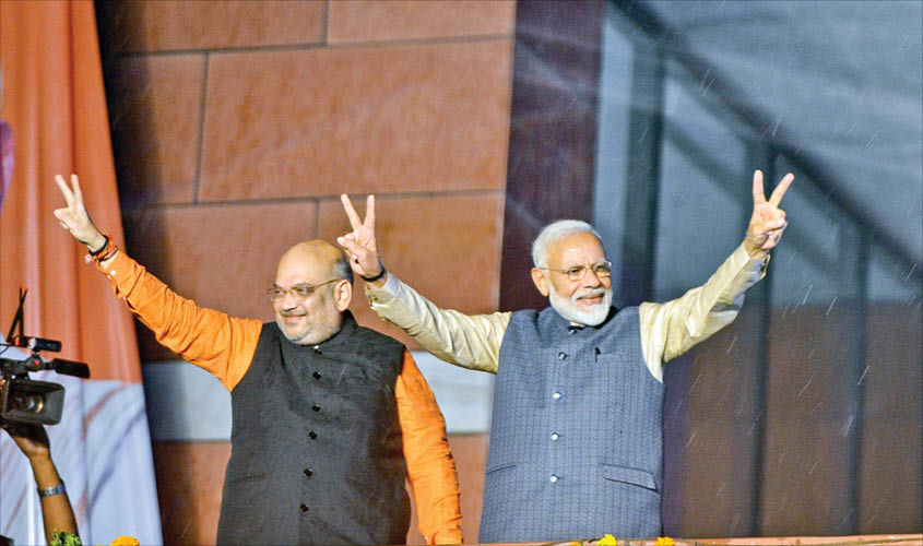 BJP chief Amit Shah and Prime Minister Narendra Modi wave at party workers during a party programme in New Delhi, on Thursday. IANS
