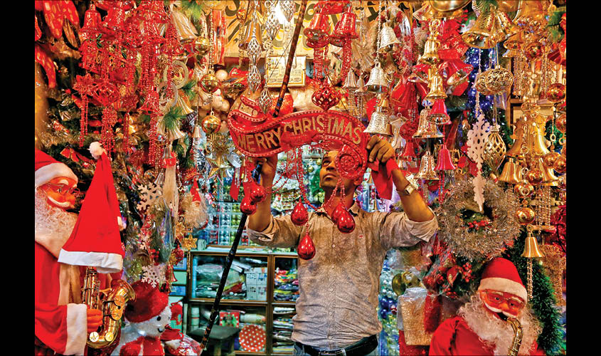 A vendor hangs decorative items in front of his shop ahead of Christmas in Kolkata, on 17 December 2018. REUTERS