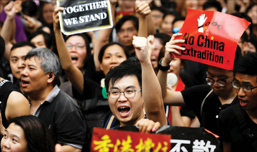 Anti-extradition bill protesters shout slogans as they march to West Kowloon Express Rail Link Station in Hong Kong, China, on 7 July. REUTERS