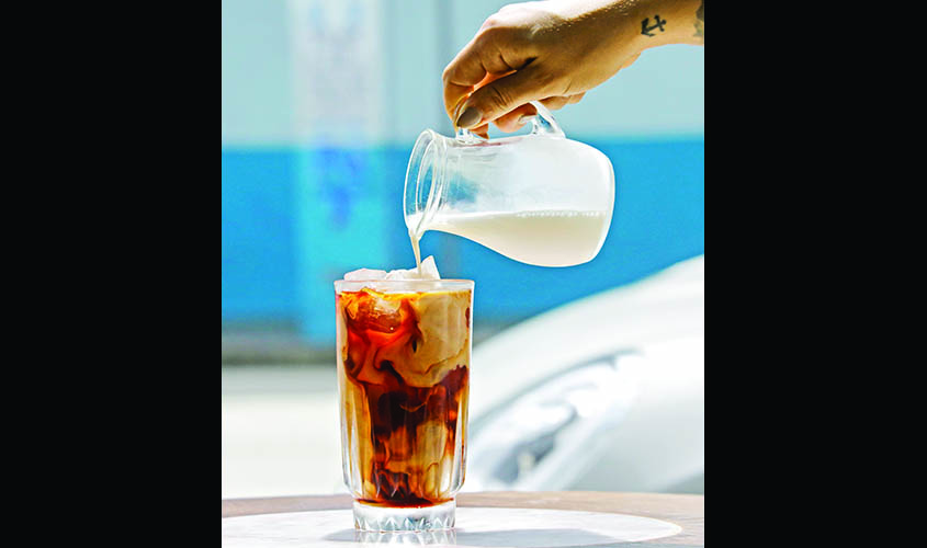 Camila Ramos, manager and co-owner of All Day coffee bar and restaurant, pours dry milk over a cold brew coffee, in Miami, FL.