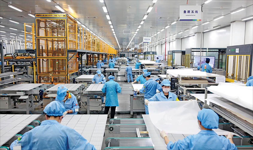 Employees work on photovoltaic solar panels at a factory of Risen Energy in Ningbo, Zhejiang province, China on 21 February. REUTERS