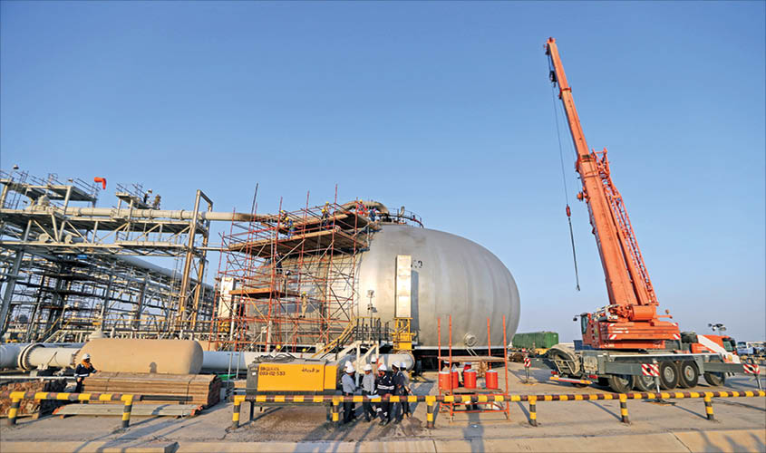 Workers are seen at the damaged site of Saudi Aramco oil facility in Abqaiq, Saudi Arabia, on Friday. REUTERS