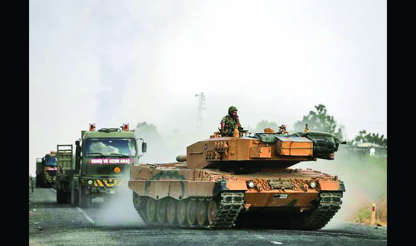 Turkish army vehicles are moving on a road near the Turkish border town of Ceylanpinar
