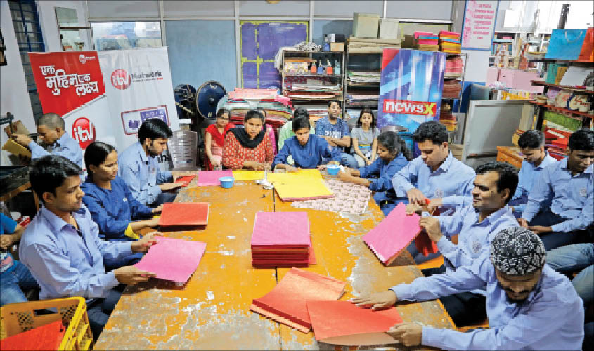 Visually-impaired at members of the Blind Relief Association making paper bags for the seven-day Diwali Bazaar.