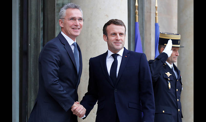 French President Emmanuel Macron welcomes NATO Secretary General Jens Stoltenberg as he arrives for a meeting at the Elysee Palace in Paris