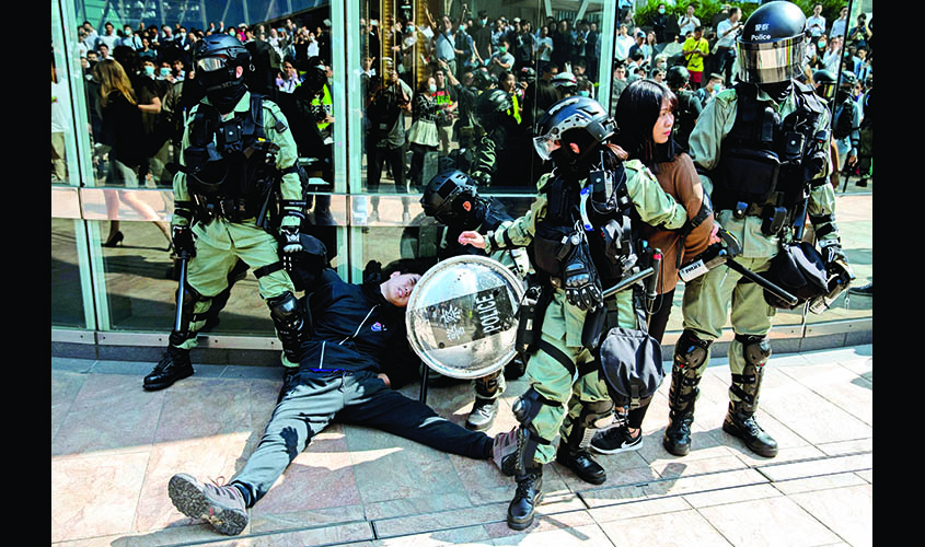 Protesters are detained by riot police officers during a demonstration at the Central District in Hong Kong