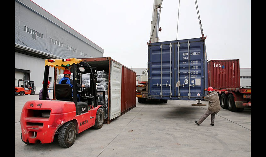 Men work on unloading the rubber imported from Belt and Road Initiative (BRI) countries at a bonded logistics centre in Nantong