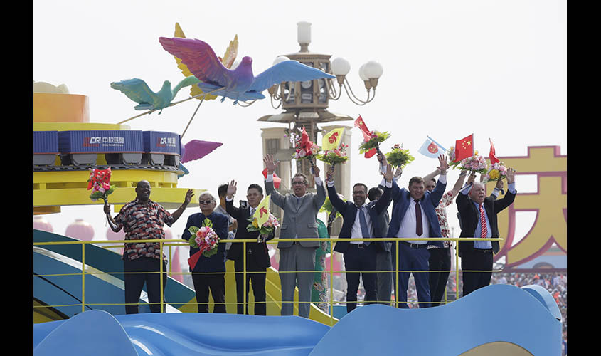 Foreigners are seen on a float featuring China Railway Express containers during the parade marking the 70th founding anniversary of People's Republic of China
