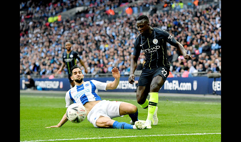 LONDON, April 7, 2019 (Xinhua) -- Manchester City's Benjamin Mendy (R) is tackled by Brighton's Martin Montoya during the FA Cup Semi-Final match between Manchester City and Brighton and Hove Albion at Wembley Stadium in London, Britain on April 6, 2019.