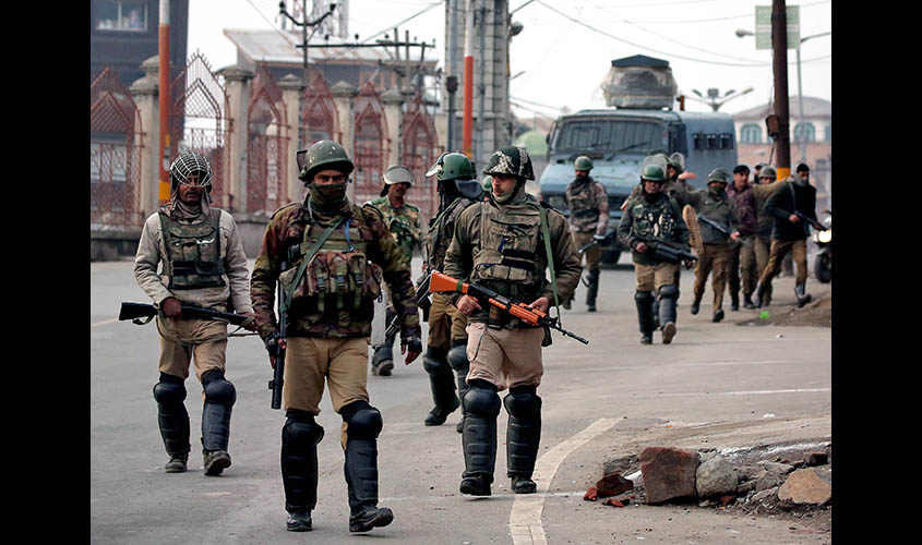 Indian Central Reserve Police Force personnel patrol a street in downtown Srinagar