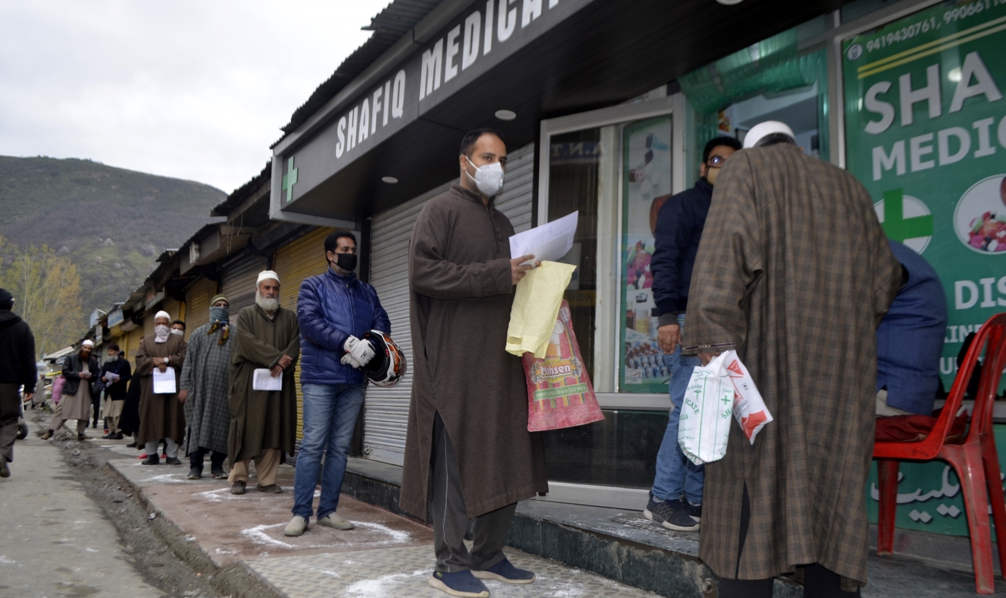 Baramulla: People strictly practising social distancing while they queue up to buy medicines outside a medical store during 21-day long nationwide lockdown imposed as a precautionary measure to contain the spread of COVID-19, in Jammu and Kashmir's Baramulla on March 25, 2020. (Photo: IANS)