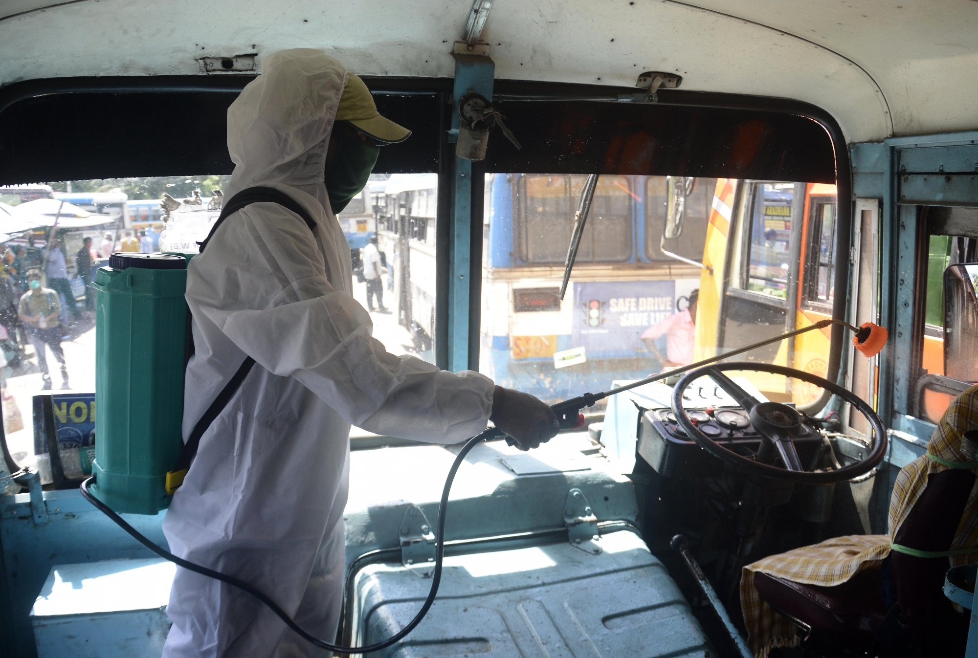 Kolkata : A worker wearing PPE suit, sprays disinfectant in a bus to contain the spread of coronavirus, in Kolkata on July 17, 2020. (Photo: IANS)
