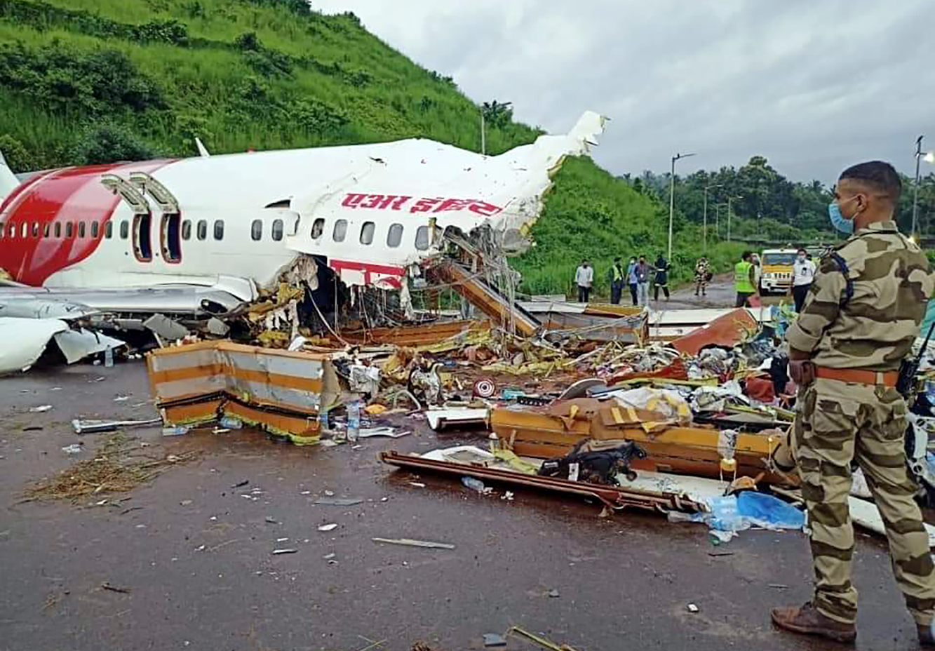 Officials inspect the wreckage of Air India Express flight