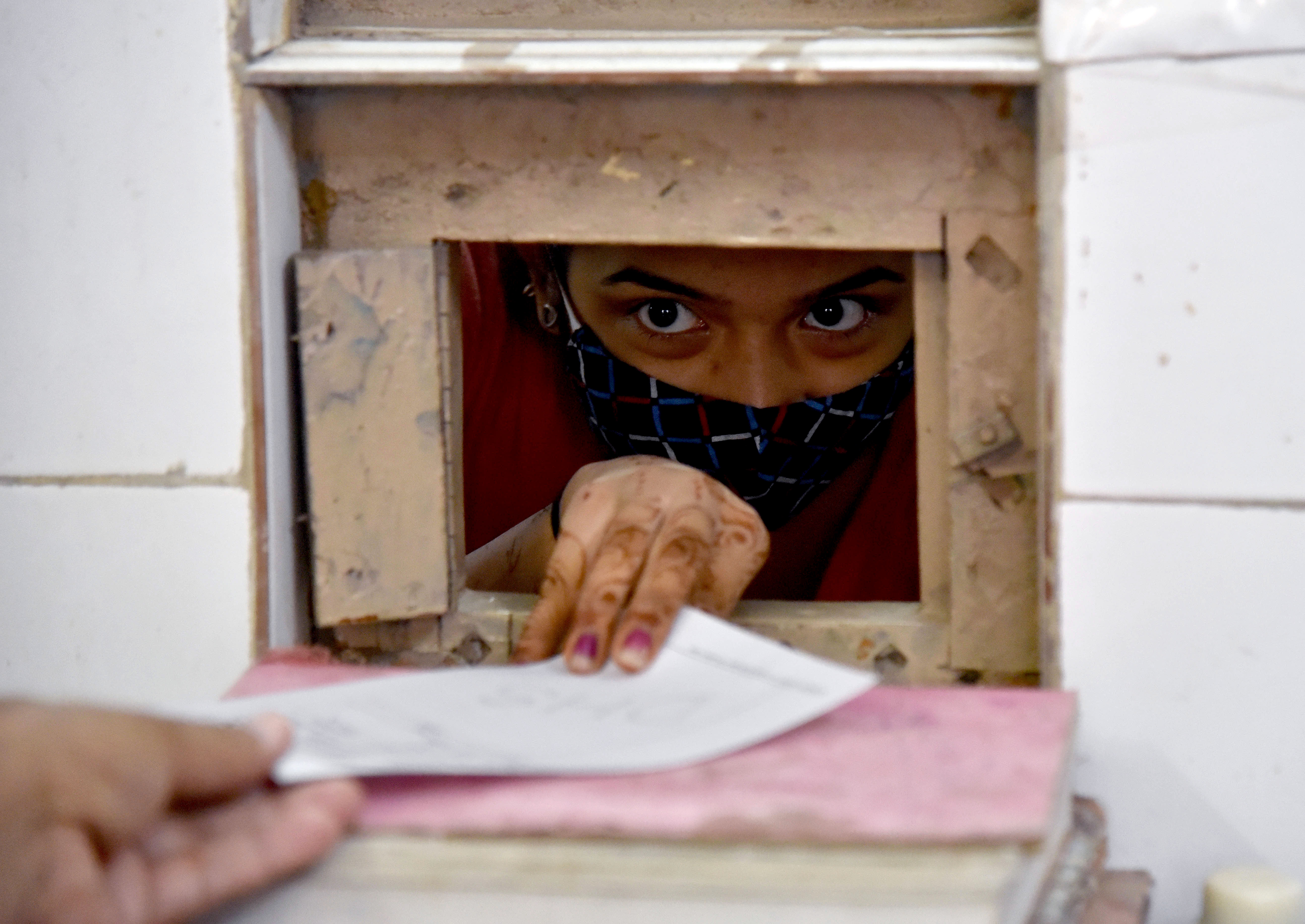 A girl taking medicines from a window after giving the swab sample