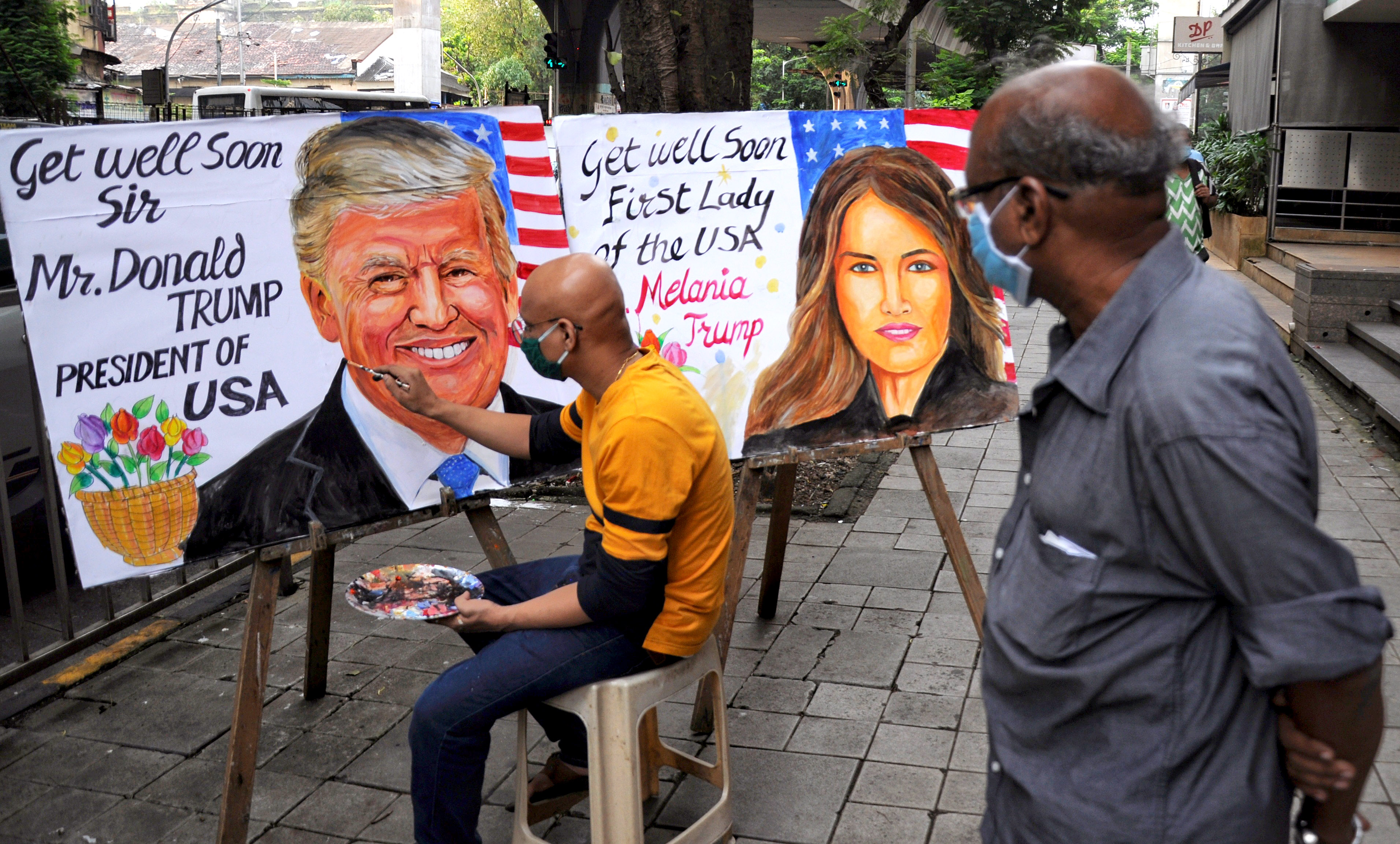 A man paints a picture of US President Donald Trump and Melania Trump