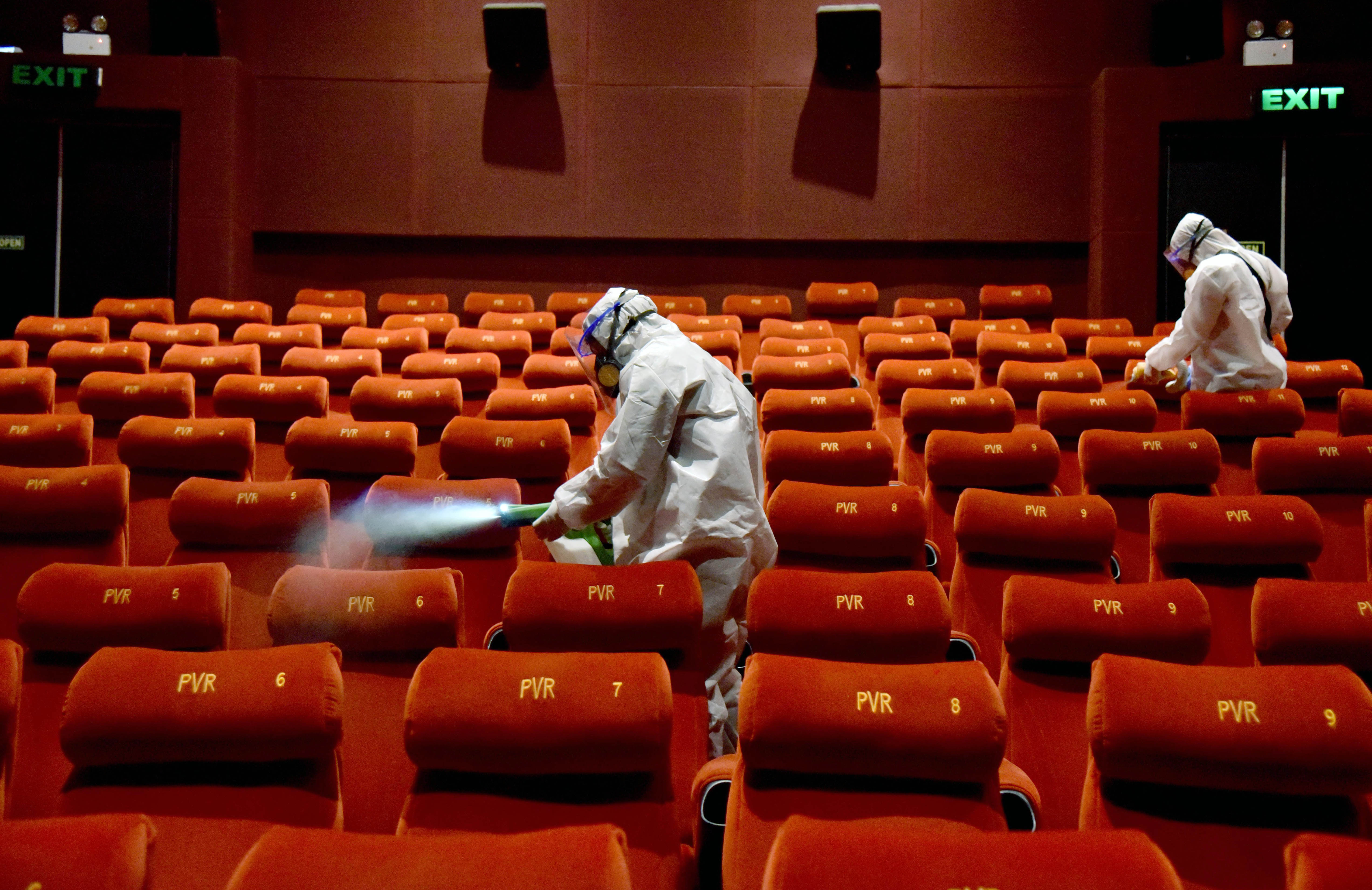 PVR Cinemas employees wearing Personal Protective Equipment (PPE) suits sanitize a cinema hall