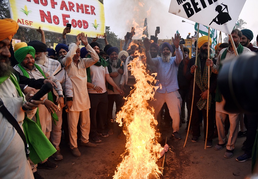 Farmers burn an effigy of Prime Minister Narendra Modi during a protest against Farm bills