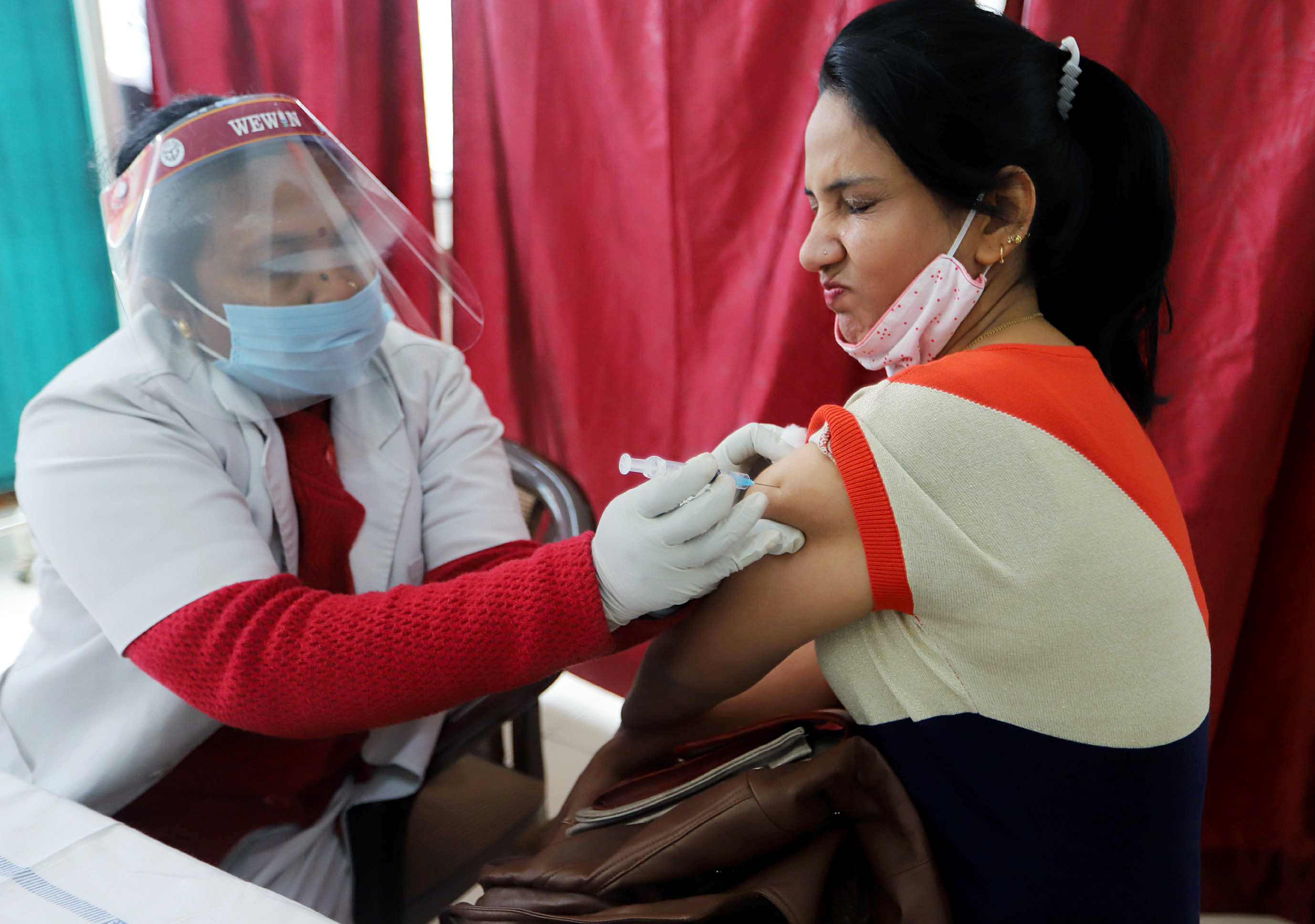 A healthcare worker receives a dose of COVISHIELD
