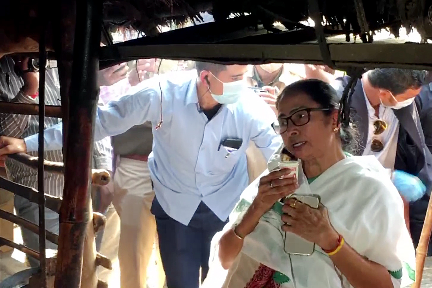 West Bengal Chief Minister Mamata Banerjee drinks tea from a stall