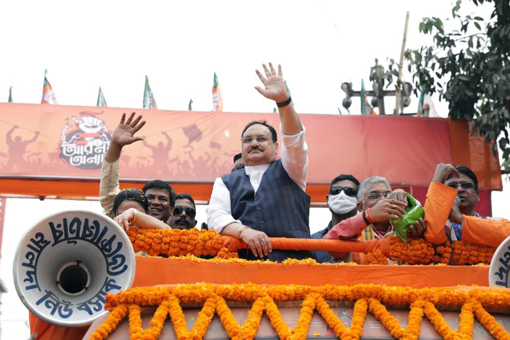 BJP National President J. P. Nadda waves to his supporters during a roadshow