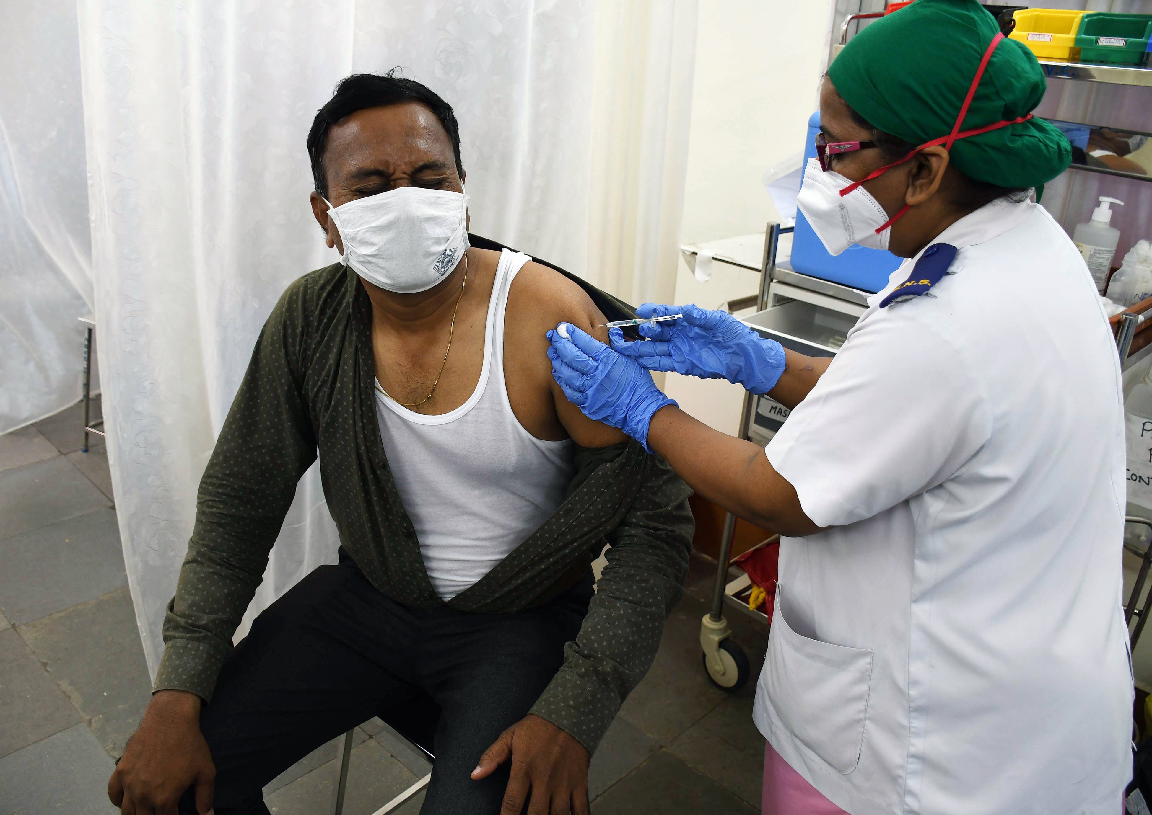 A medic injects COVID-19 vaccine to a frontline health worker