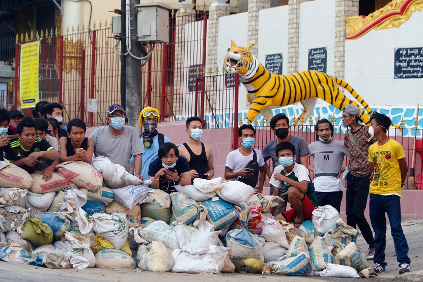 Protesters stand behind a barricade at Sanchaung district in Yangon
