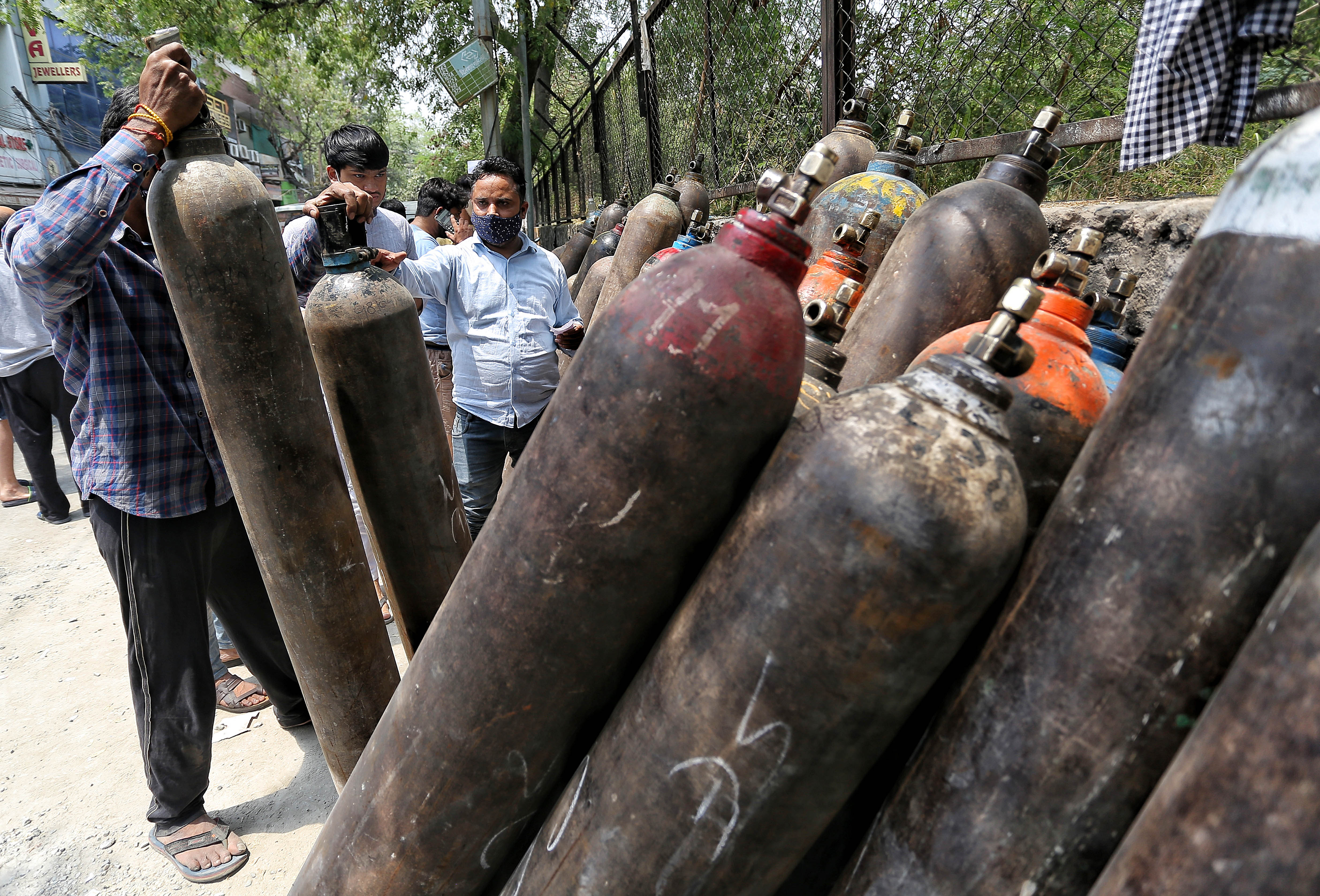 Relatives of Covid patients come with oxygen cylinders to get refilled at a dealer