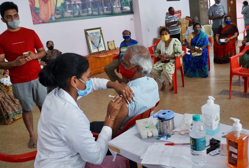 A medic inoculates the dose of a COVID-19 vaccine to the elderly man