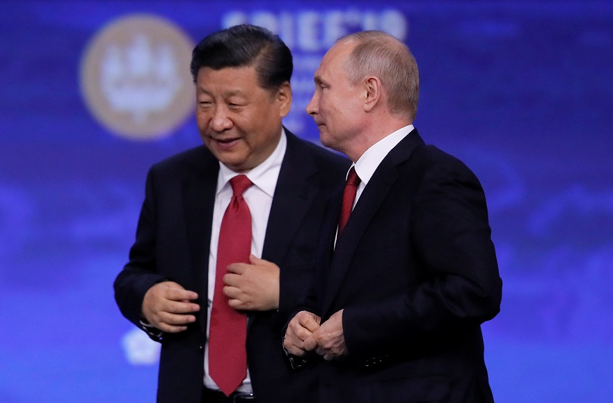 Chinese President Xi Jinping and Russian President Vladimir Putin leave after a session of the St. Petersburg International Economic Forum