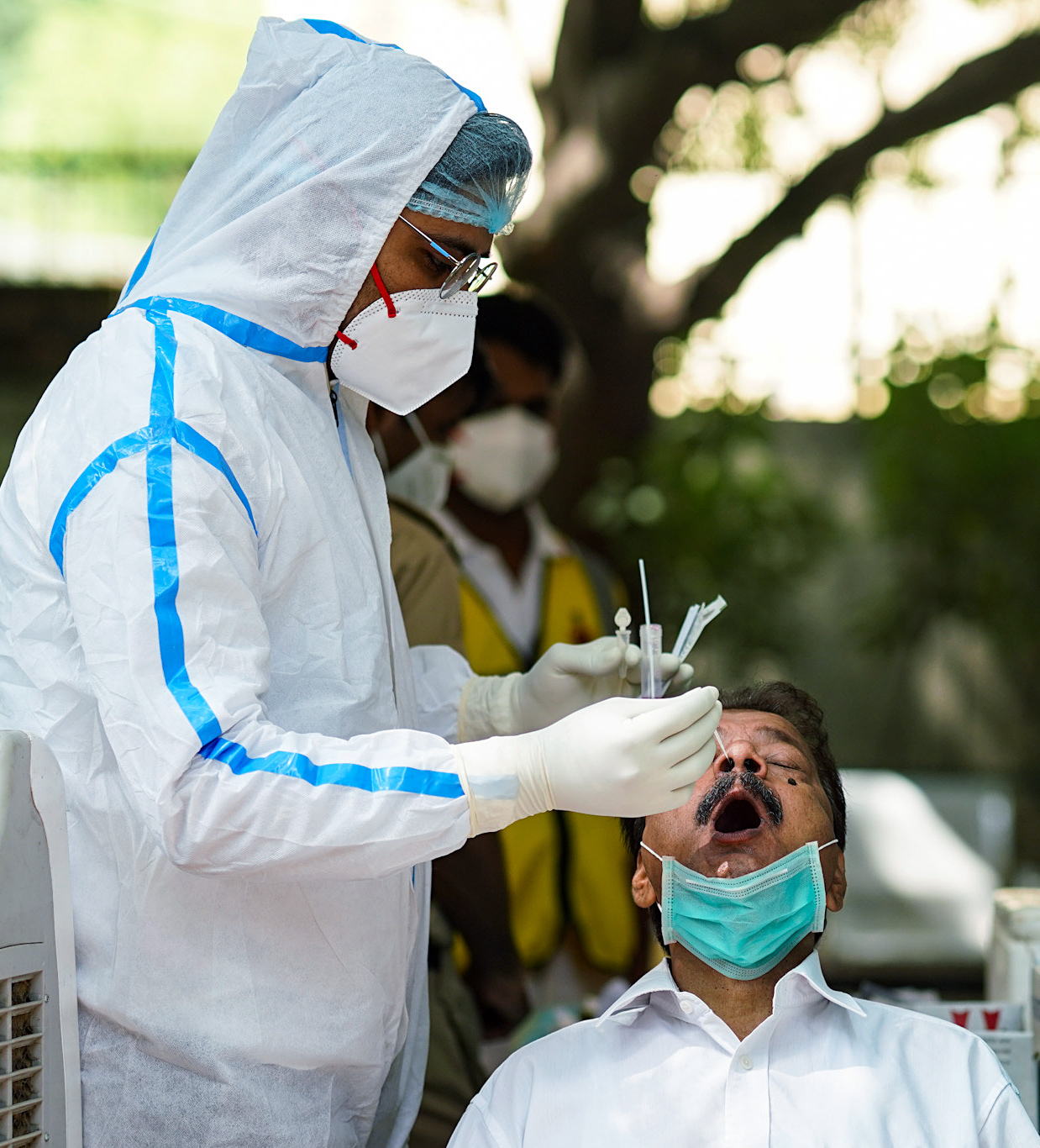 A healthcare worker collects a nasal sample of a beneficiary for the Covid-19 testing