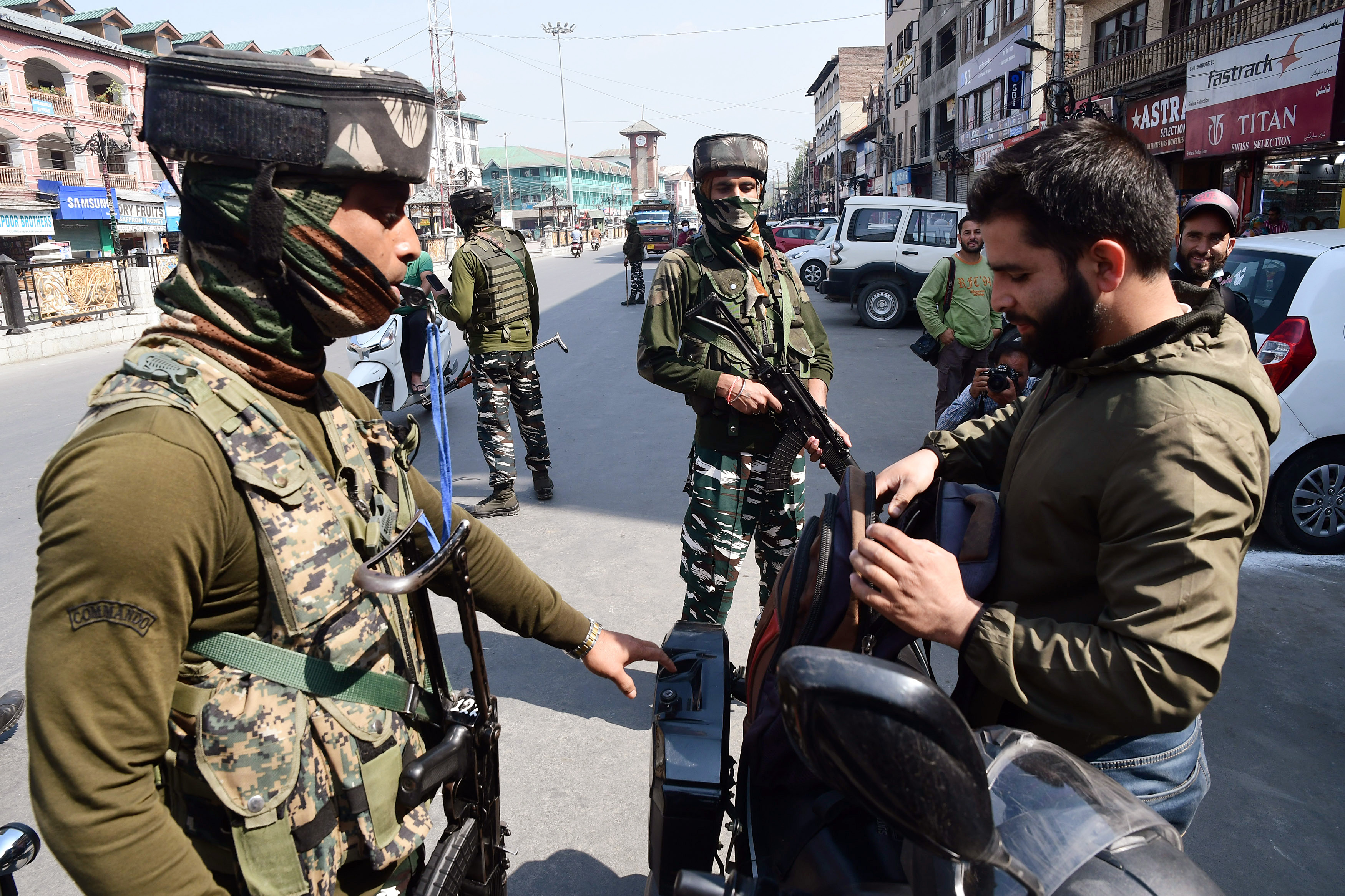 Security personnel check commuters during a high alert