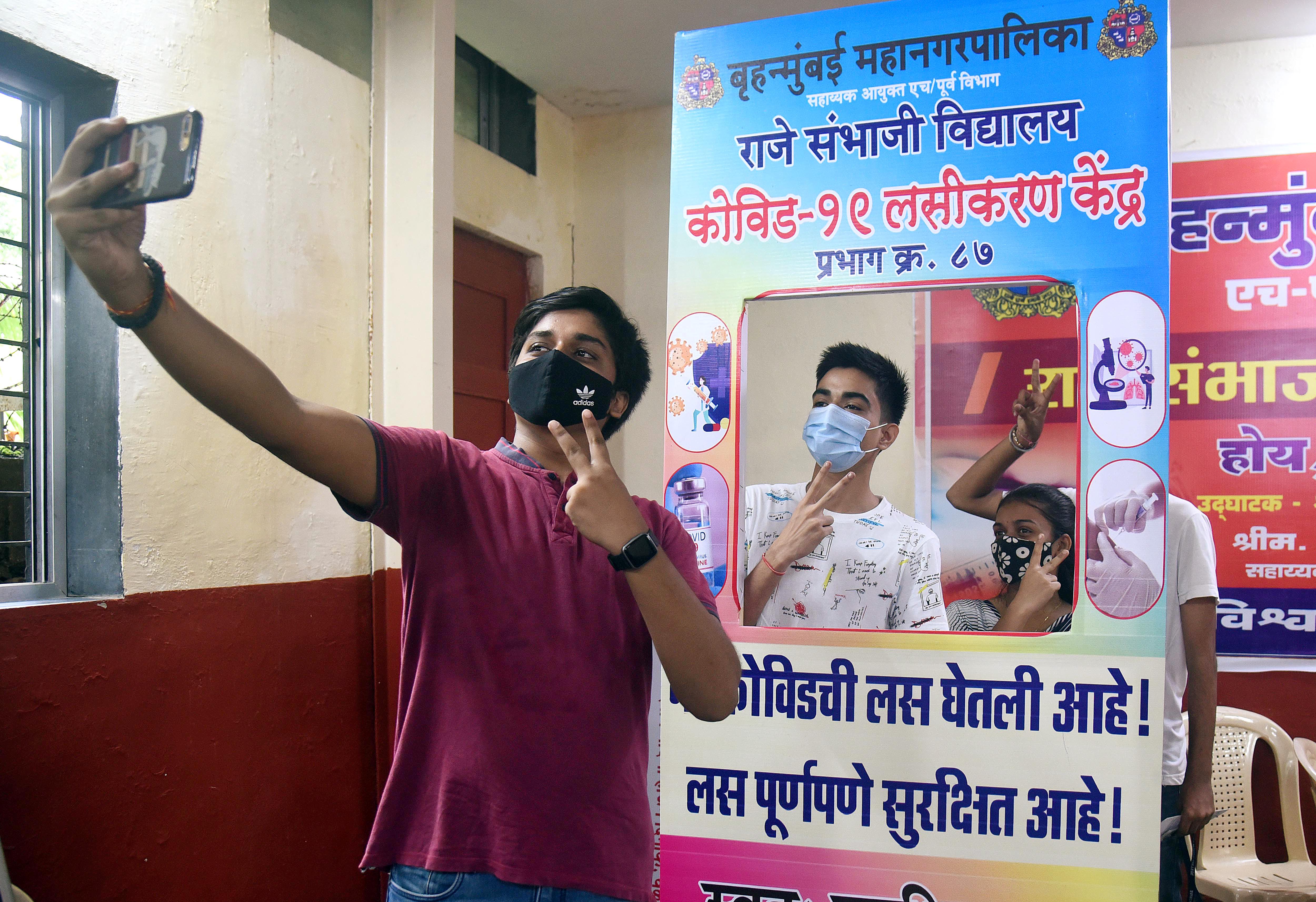 Students take selfie after receiving a dose of the COVID-19 vaccine during a special vaccination drive for students