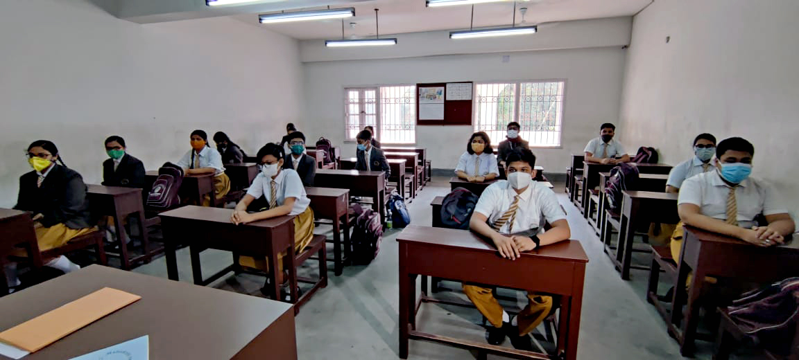 Students attend a class at Maharishi Vidya Mandir School as the schools reopen