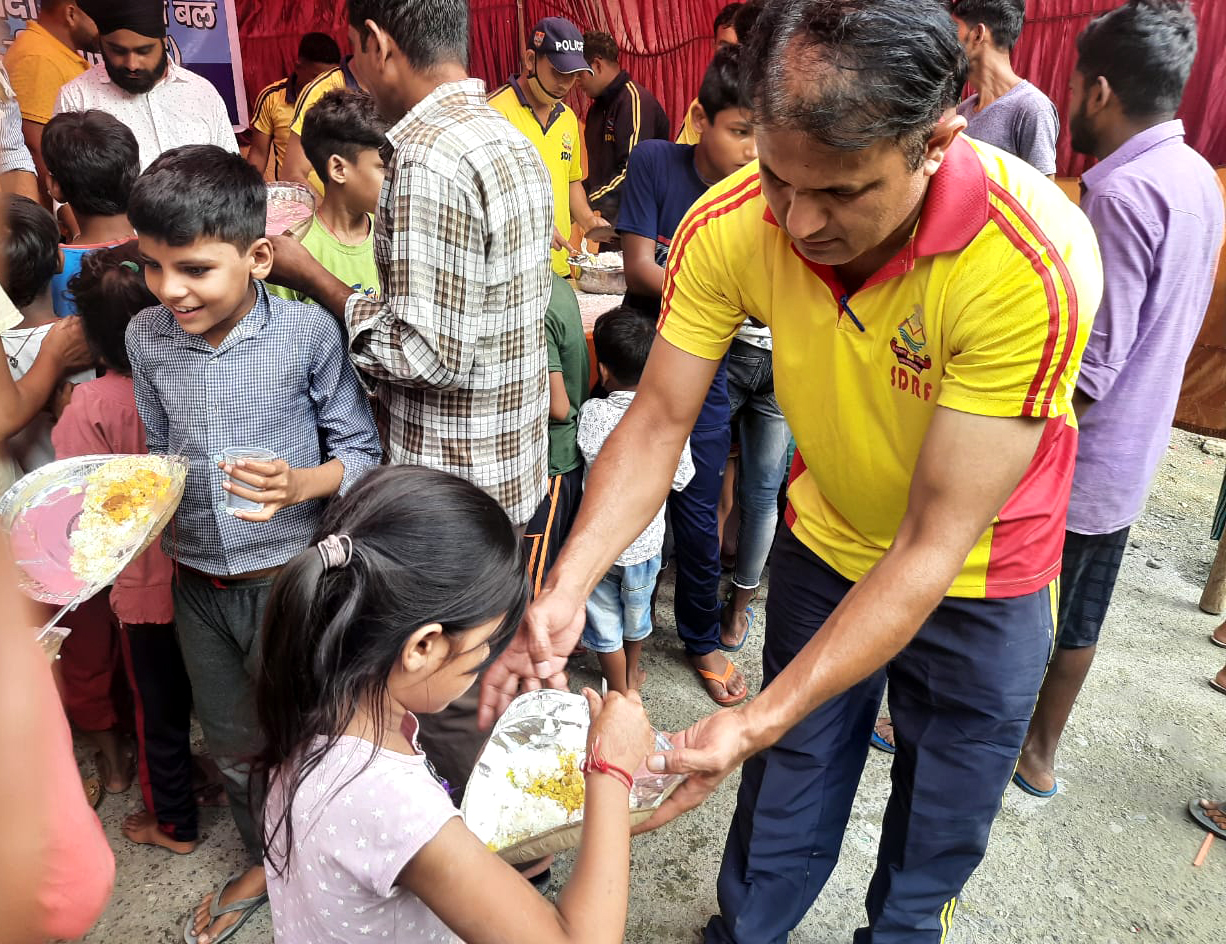 Free food is distributed to disaster victims at a disaster relief camp by SDRF