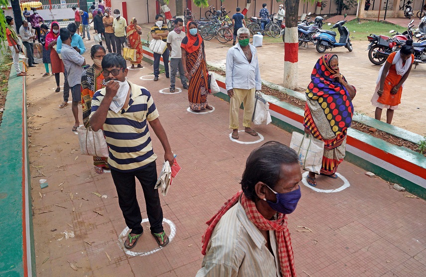 Below Poverty Line (BPL) card holders stand in queues to get the ration