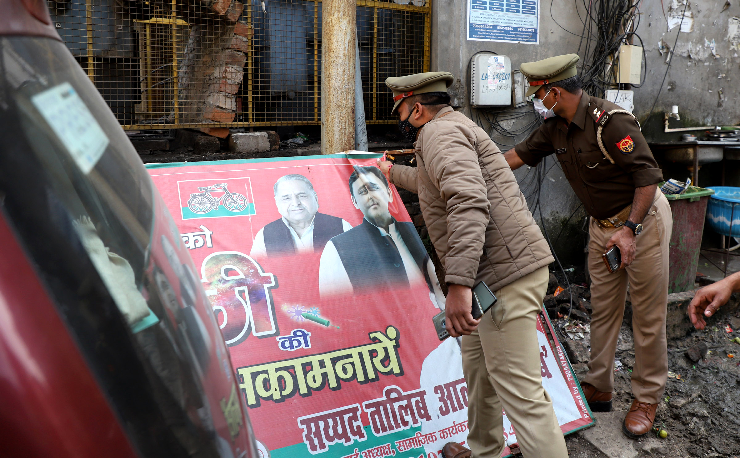 Police officials remove the hoardings of political leaders