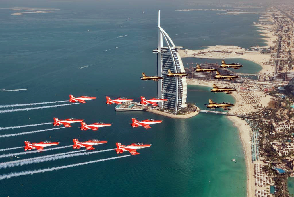 Nine Hawk 132 of IAF's Suryakiran Aerobatics team fly in sync with seven Aermacchi MB-339 of UAE's Al Fursan Display team over Burj Al Arab