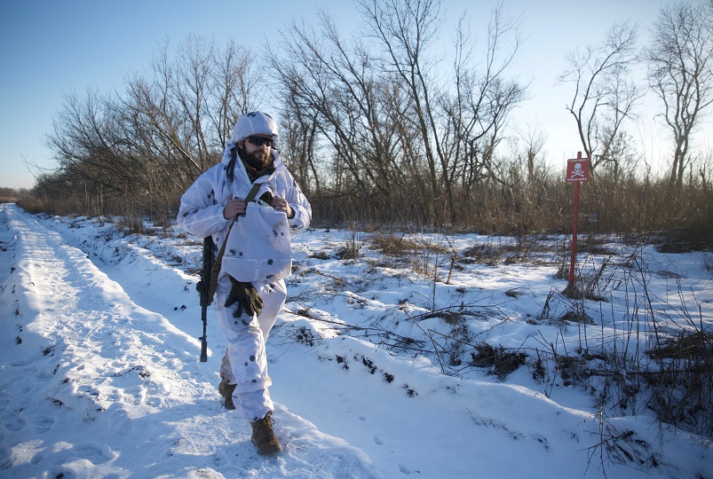 A service member of the Ukrainian armed forces walks at combat positions in Donetsk region