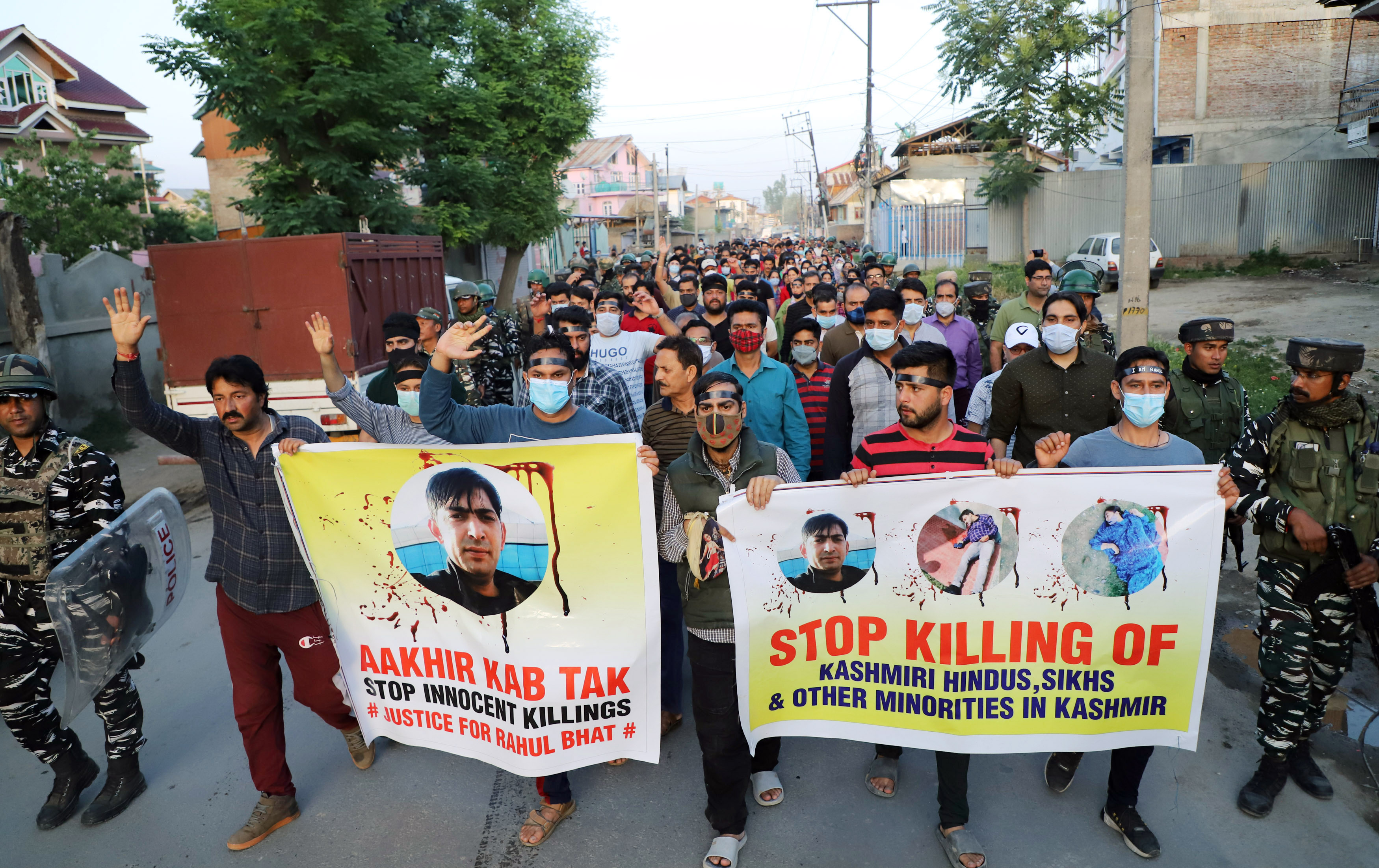 Kashmiri pandits holding banners protest march against the killing of Rahul Bhat
