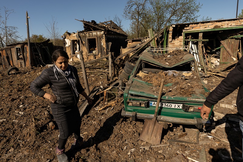 Woman stands in front of her house after a missile strike hit a residential area in Bakhmut in the Donetsk region