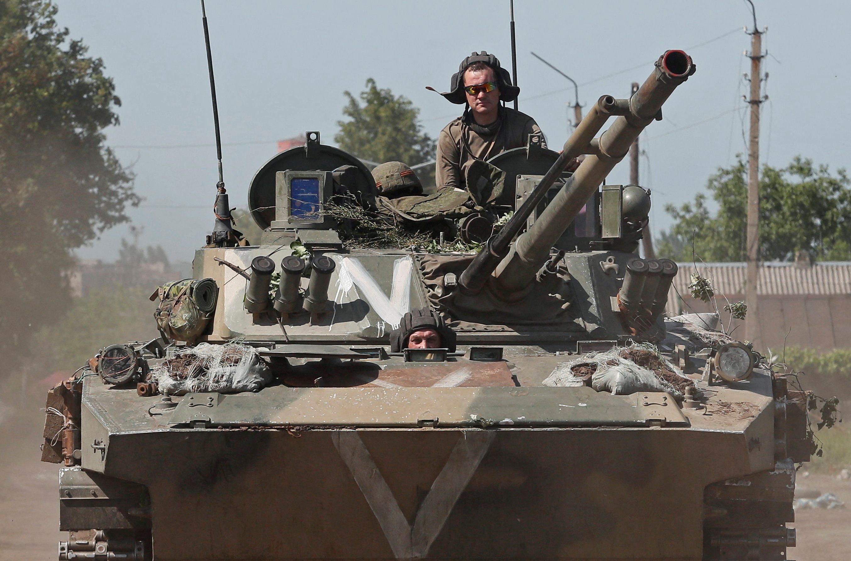 Service members of pro-Russian troops ride an infantry fighting vehicle in Popasna