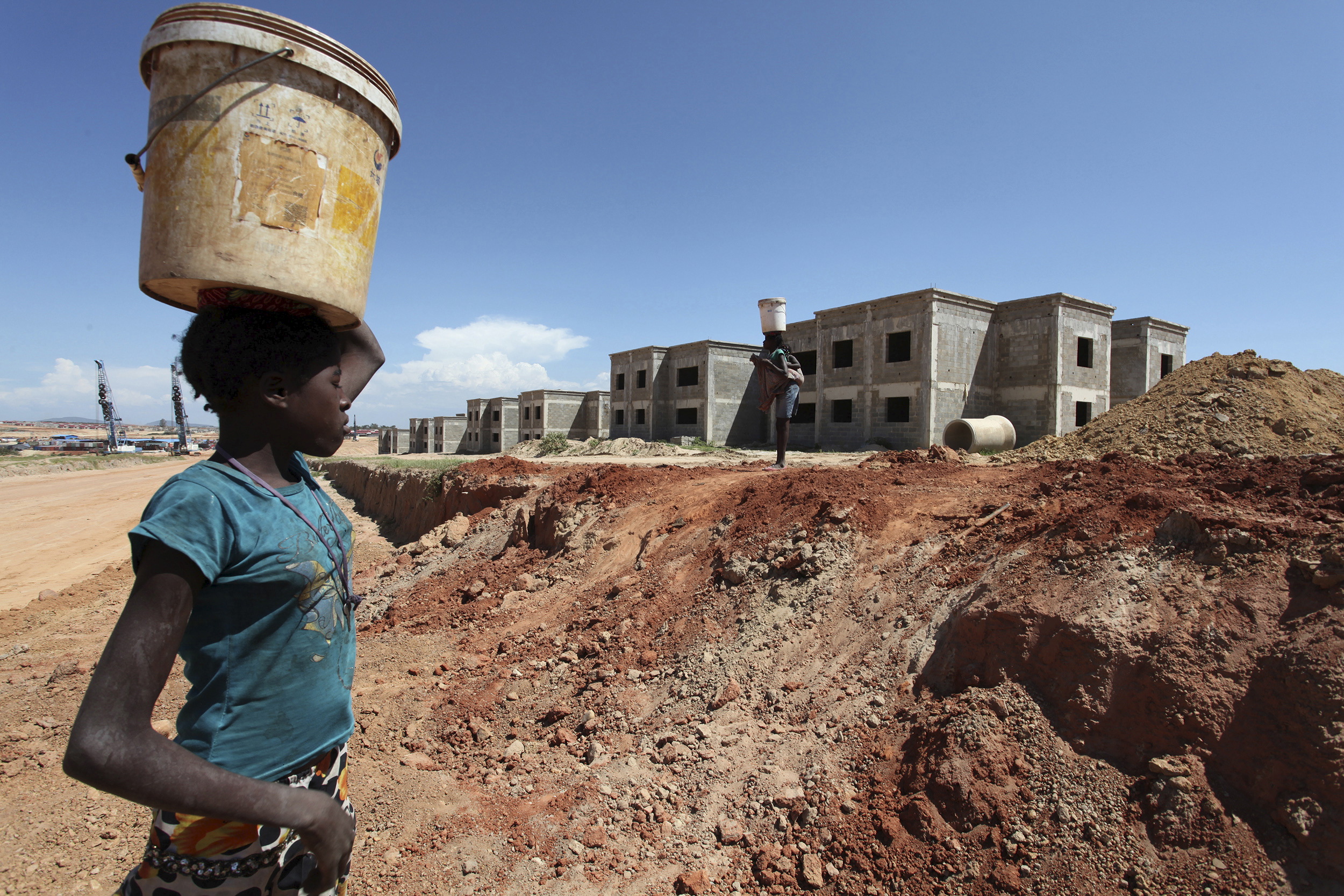 A woman walks past a Chinese construction site in Lubango