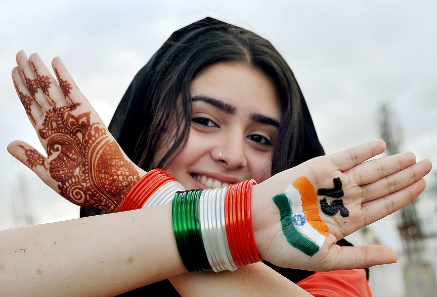 A student poses for a photo after painting the National flag on her hand