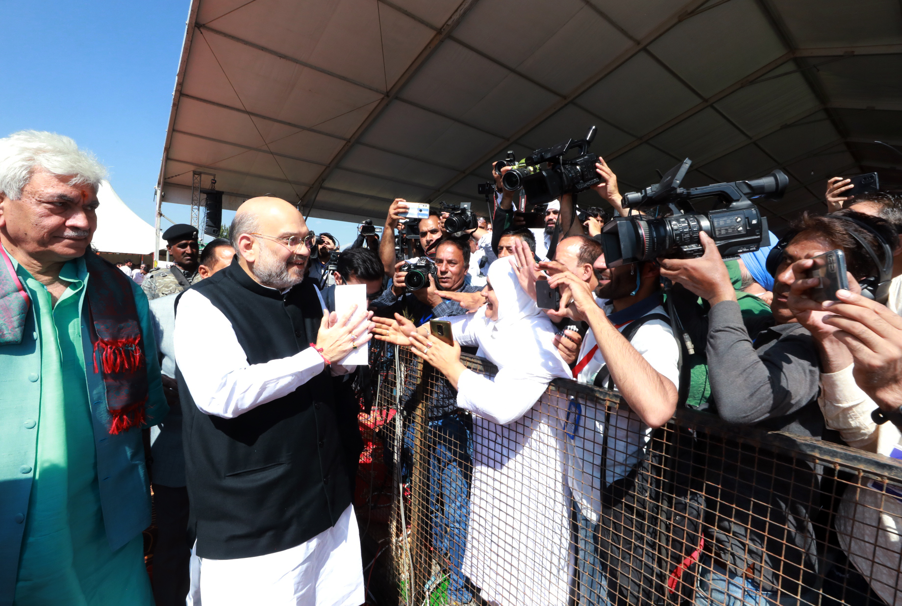Union Home Minister Amit Shah greets the people gathered for a public rally,