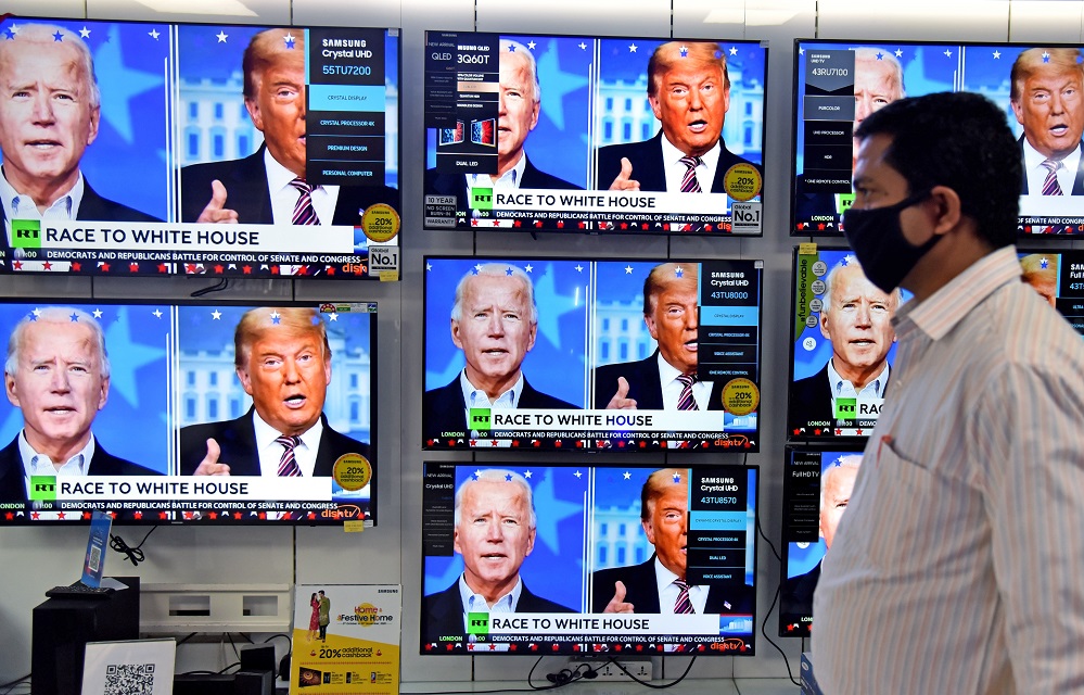 Employee watches US election results 2020 on TV Screens in New Delhi