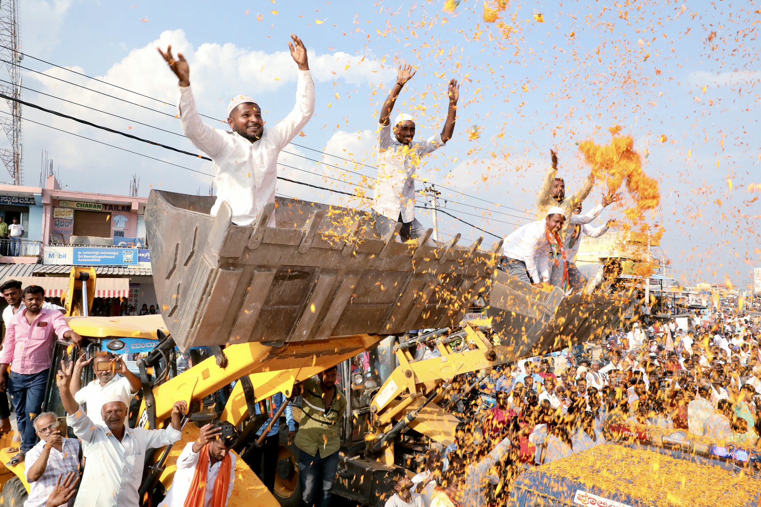 BJP supporters sprinkle flower petals during a road show
