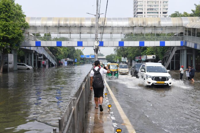Vehicles wade through a flooded road as ITO closed
