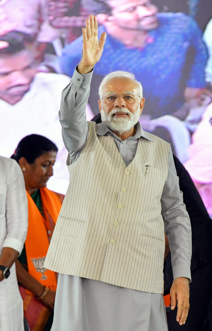 Prime Minister Narendra Modi waves to supporters during the inauguration